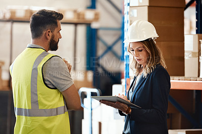 Buy stock photo Cropped shot of an attractive young female businesswoman talking to a male warehouse worker