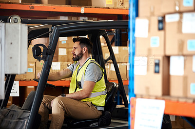 Buy stock photo Cropped shot of a handsome young male warehouse worker driving a forklift