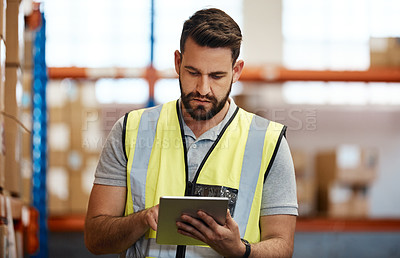 Buy stock photo Cropped shot of a handsome young male warehouse worker checking stock