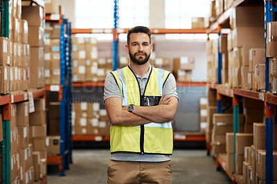 Buy stock photo Cropped portrait of a handsome young male warehouse worker standing with his arms crossed