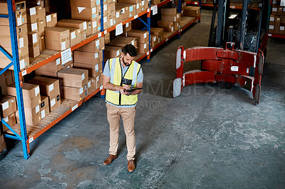 Buy stock photo High angle shot of a handsome young male warehouse worker checking stock