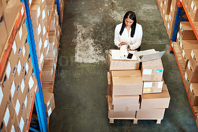 Buy stock photo High angle shot of an attractive mature female warehouse worker working on a laptop