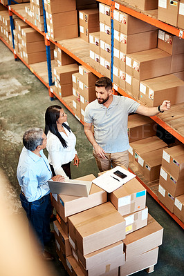 Buy stock photo High angle shot of three warehouse workers checking on distribution logistics