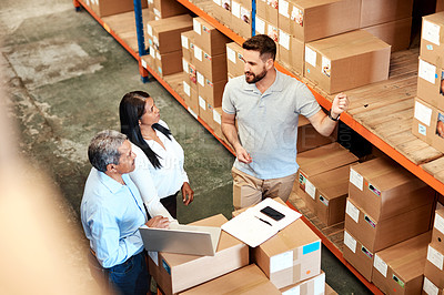 Buy stock photo High angle shot of three warehouse workers checking on distribution logistics