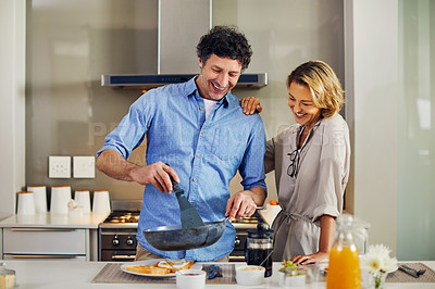 Buy stock photo Shot of a mature man preparing breakfast for him and his wife at home
