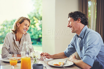 Buy stock photo Shot of a mature couple having a leisurely breakfast together at home