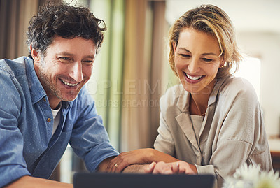 Buy stock photo Shot of a mature couple using a digital tablet at home