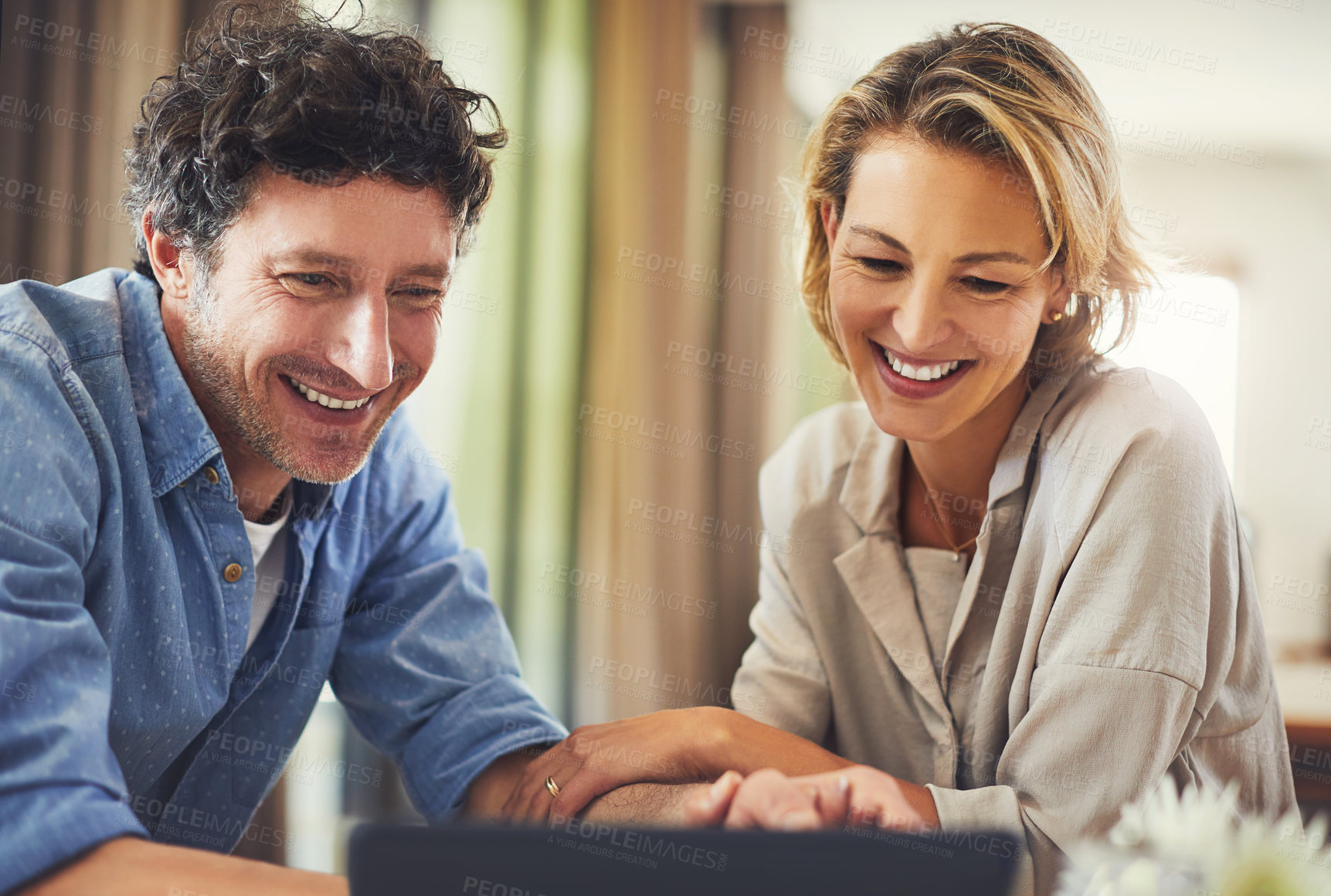 Buy stock photo Shot of a mature couple using a digital tablet at home