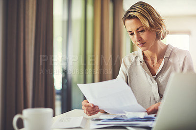 Buy stock photo Shot of a mature woman going over her finances at home