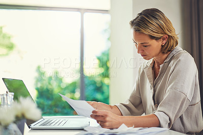 Buy stock photo Shot of a mature woman going over her finances at home