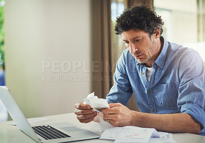 Buy stock photo Shot of a mature man going over his finances at home
