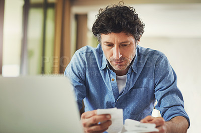 Buy stock photo Shot of a mature man going over his finances at home