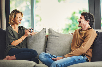 Buy stock photo Shot of a mature couple chatting and having coffee while relaxing on the sofa at home
