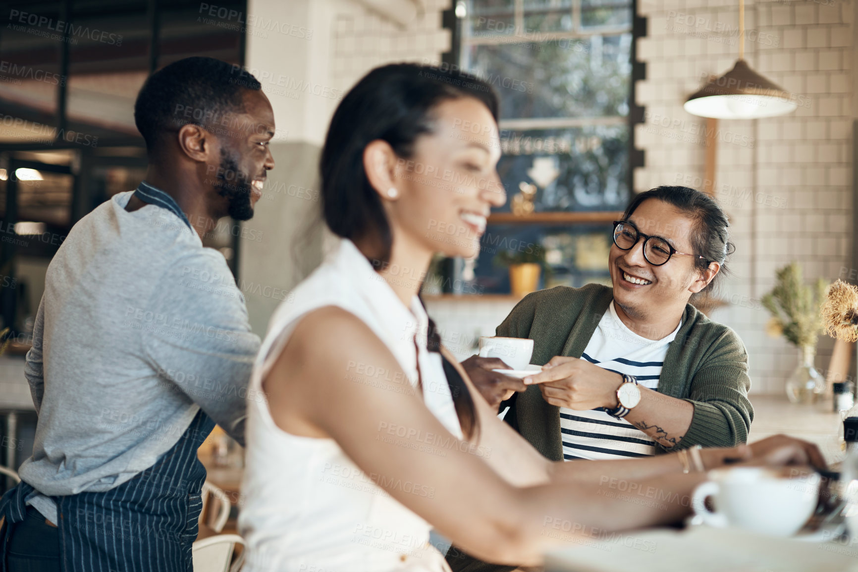 Buy stock photo Cropped shot of a handsome young businessman sitting with a female colleague and getting a coffee in a cafe