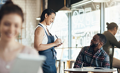 Buy stock photo Cropped shot of an attractive young waitress taking down an order for a male customer in the cafe