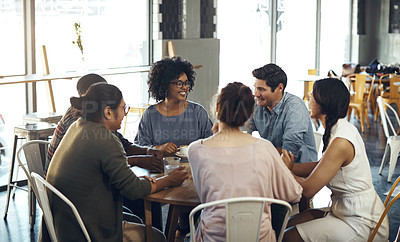 Buy stock photo Cropped shot of a diverse group of friends sitting together and bonding in a coffee shop