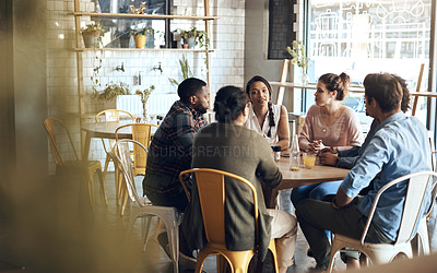 Buy stock photo Cropped shot of a diverse group of businesspeople sitting together and having a discussion in a coffee shop