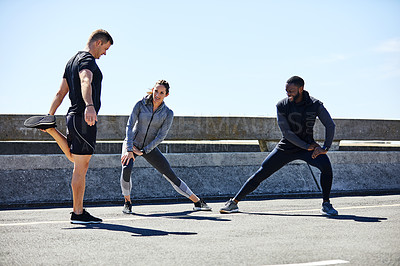Buy stock photo Shot of a fitness group stretching before their run