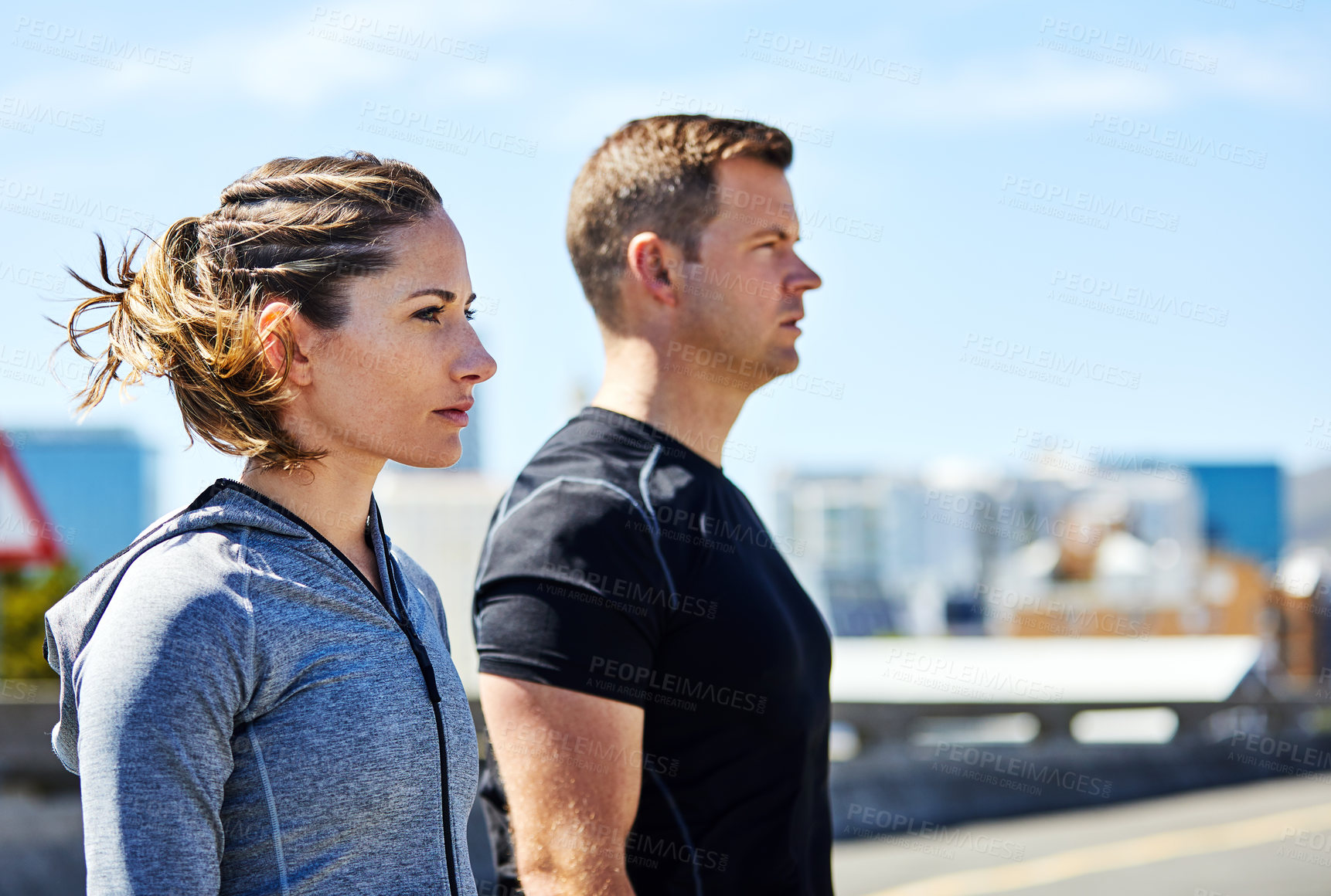 Buy stock photo Shot of two sporty young people out for a run in the city
