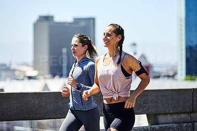 Buy stock photo Cropped shot of two young women out for a run in the city