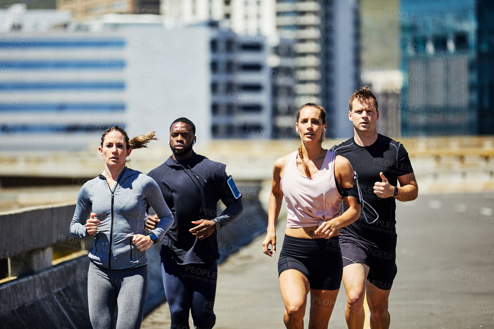 Buy stock photo Shot of a group of sporty young people out for a run in the city