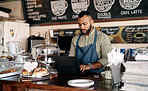 Managing his admin while it's quiet in the cafe