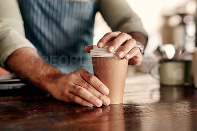 Buy stock photo Closeup shot of a barista sealing a lid on a coffee cup in a cafe