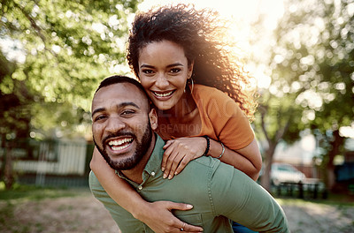 Buy stock photo Portrait a young man giving his girlfriend a piggyback ride outdoors