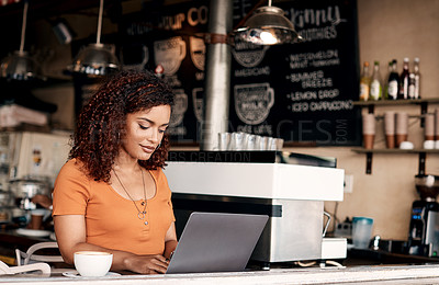 Buy stock photo Shot of a young woman working on a laptop in a cafe