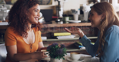 Buy stock photo Shot of two young women chatting in a cafe