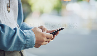 Buy stock photo Closeup shot of an unrecognisable woman using a cellphone while out in the city