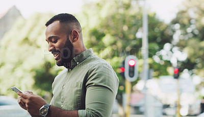 Buy stock photo Shot of a young man using a cellphone while out in the city