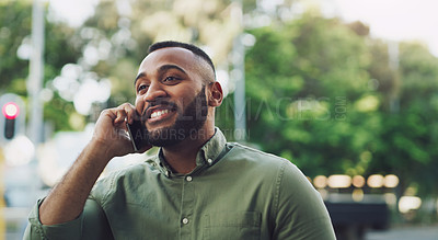 Buy stock photo Shot of a young man talking on a cellphone while out in the city