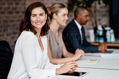 Buy stock photo Shot of an attractive young businesswoman sitting with her coworkers during a meeting in the office