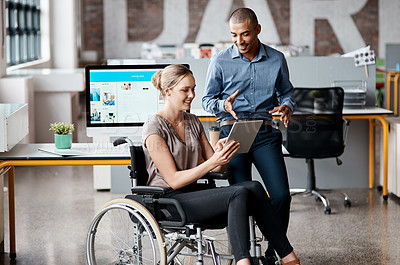 Buy stock photo Shot of two businesspeople using a digital tablet together in an office