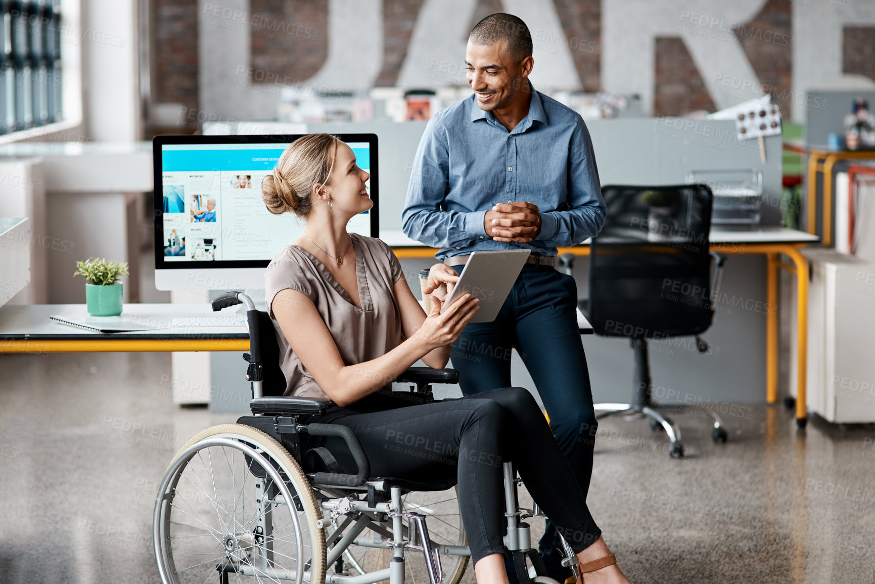 Buy stock photo Shot of two businesspeople using a digital tablet together in an office