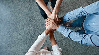 Buy stock photo High angle shot of a group of unrecognisable businesspeople joining their hands together in a huddle