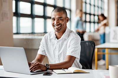 Buy stock photo Portrait of a young businessman working on a laptop in an office