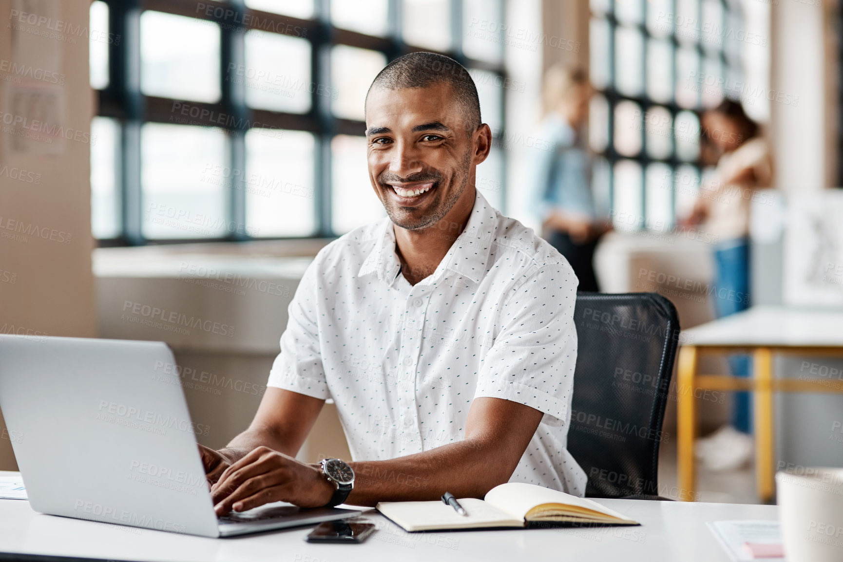 Buy stock photo Portrait of a young businessman working on a laptop in an office
