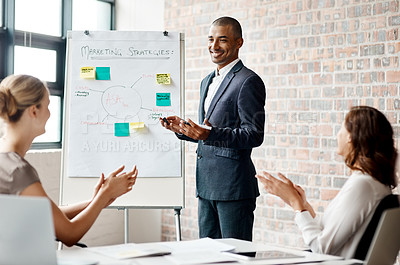 Buy stock photo Shot of a young businessman receiving applause during a presentation in an office