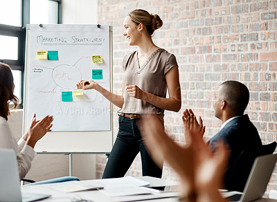 Buy stock photo Shot of a young businesswoman receiving applause during a presentation in an office