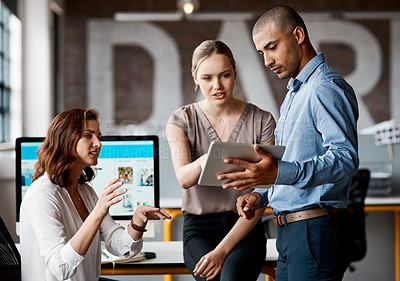 Buy stock photo Shot of a group of businesspeople using a digital tablet together in an office