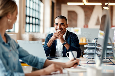 Buy stock photo Shot of a young businessman having a discussion with his colleague in a modern office