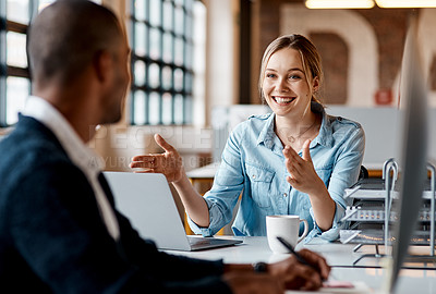 Buy stock photo Shot of a young businesswoman having a discussion with her colleague in a modern office