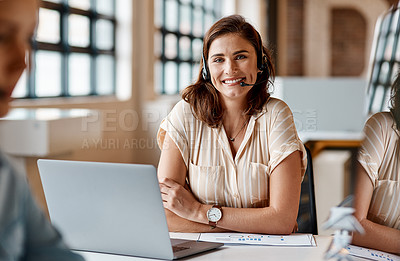 Buy stock photo Shot of a young woman using a headset and laptop in a modern office
