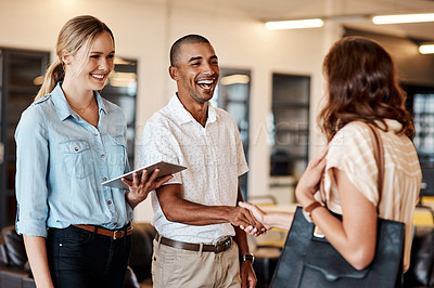 Buy stock photo Shot of a young businessman shaking hands with a colleague during a meeting in a modern office