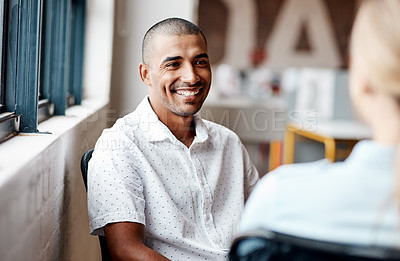 Buy stock photo Shot of a young businessman having a discussion with a colleague in a modern office