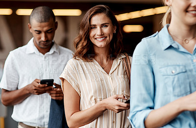 Buy stock photo Shot of a young businesswoman using a smartphone while waiting in line in a modern office