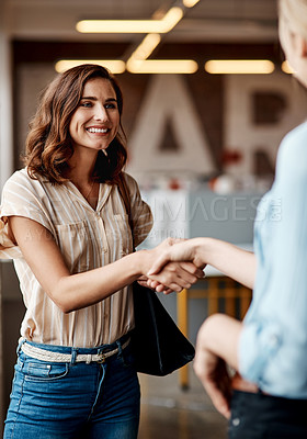 Buy stock photo Shot of a young businesswoman shaking hands with a colleague during a meeting in a modern office