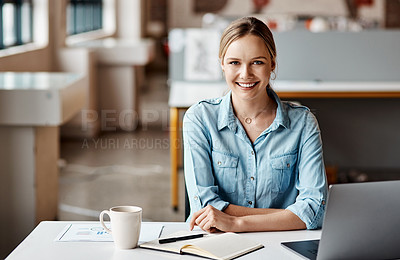 Buy stock photo Shot of a young businesswoman using a laptop and making notes in a modern office